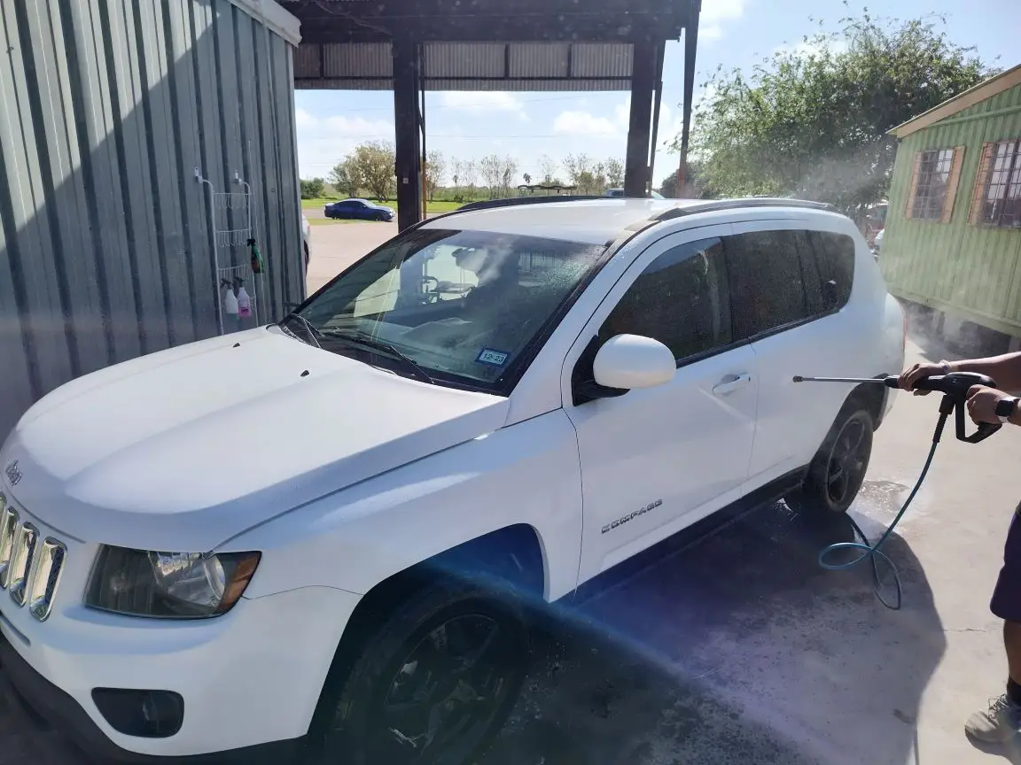A white jeep compass that is being sprayed off