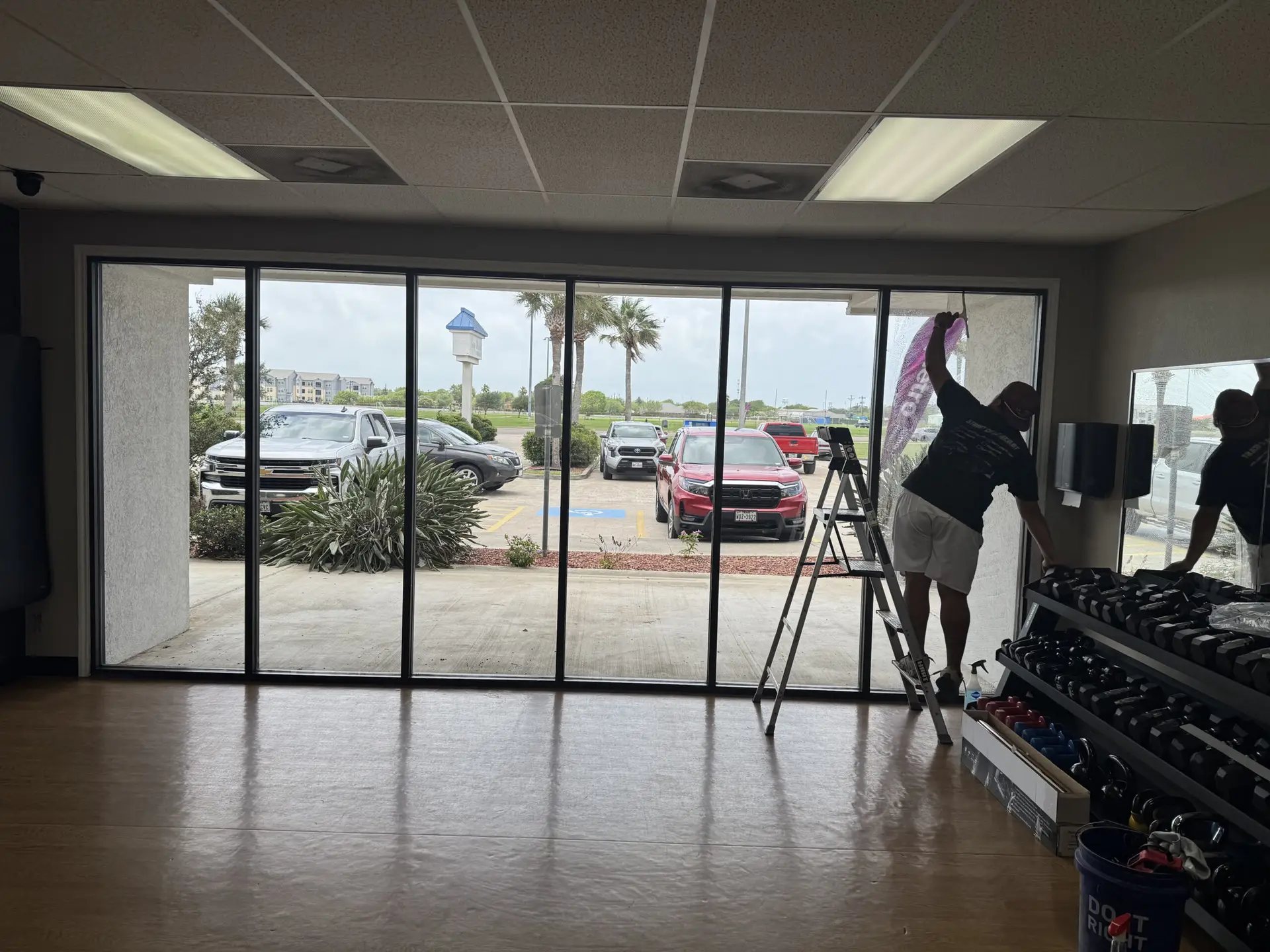 An employee is preparing windows for a commercial tint application